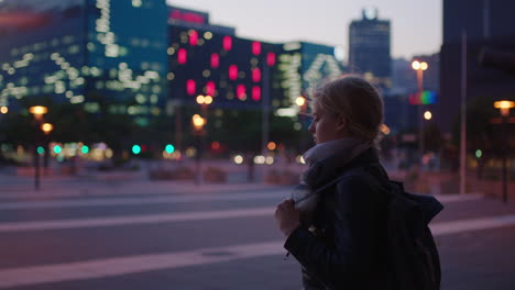 retrato de una joven rubia mirando las luces de la ciudad esperando disfrutar del estilo de vida de viaje urbano