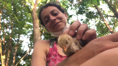 chica acariciando pollito en la selva amazónica