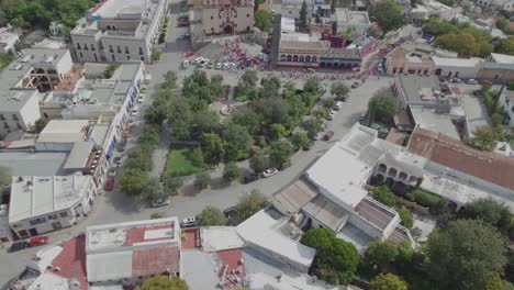 Aerial-tilting-shot-of-people-entering-the-church-in-downtown-Santiago-Nuevo-Leon,-Mexico