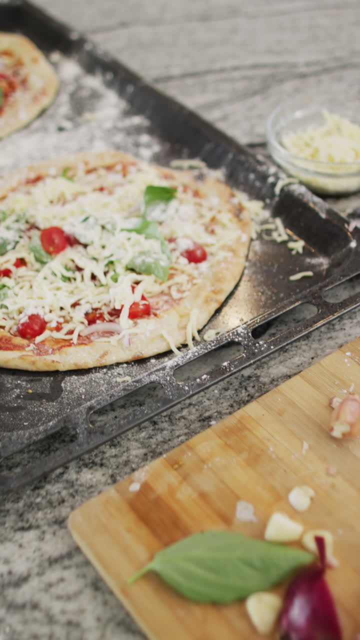 Vertical video of red onion and pizza on baking sheet in kitchen, slow motion