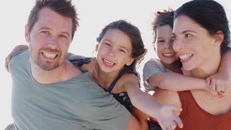 retrato al aire libre de la familia en vacaciones de playa de verano contra el sol abrasador