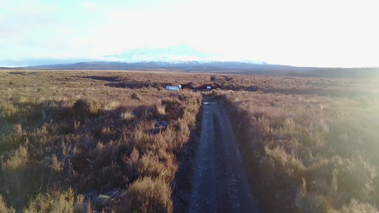 disparo de seguimiento aéreo de una persona corriendo inclinándose hacia una montaña nevada