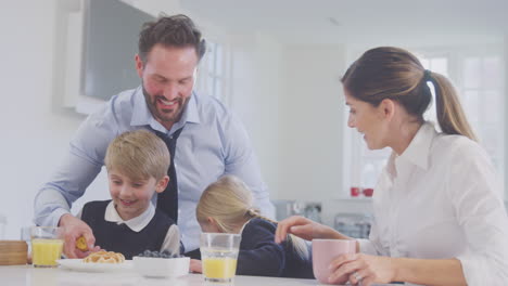 children wearing school uniform in kitchen eating breakfast waffles as parents get ready for work