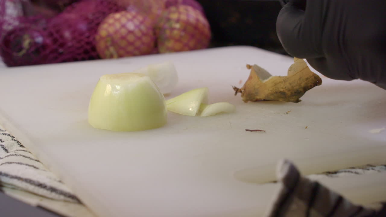 튜닉과 질이 있는 잎은 절단판에 칼로 양파를 잘라낸다.