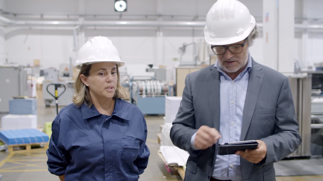 старший начальник завода с табличкой комментирует работу машин