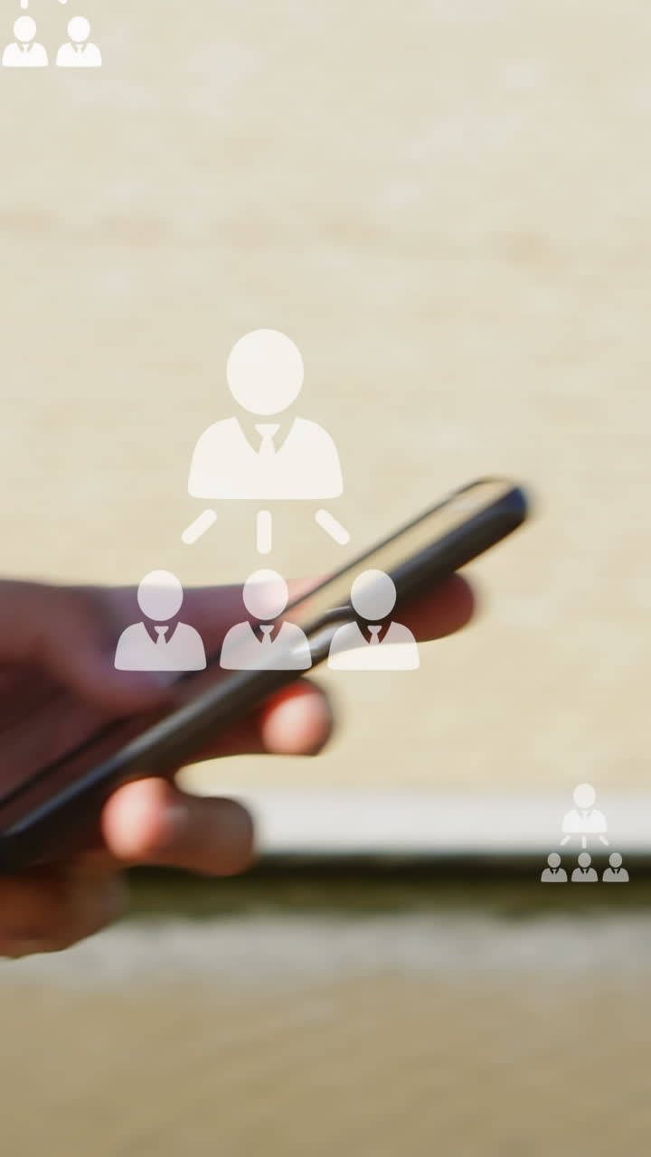 animación de iconos de usuario sobre las manos de un hombre biracial que usa un teléfono inteligente en la ciudad