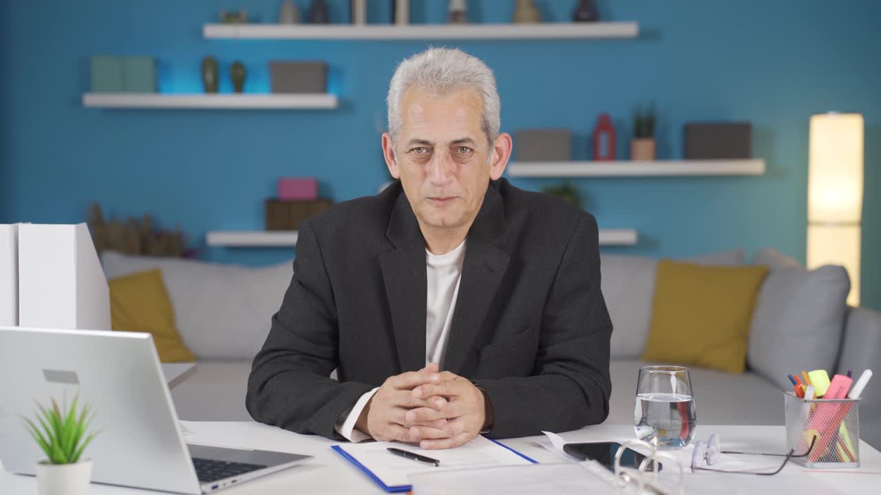 집에서 일하는 사무직 노동자는 혐오와 증오로 카메라를 쳐다보고 있습니다.