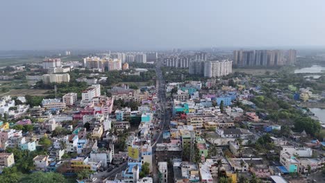 an aerial view of a city in tamil nadu, india. residential and taller modern buildings, road networks with vehicles, and some green undeveloped areas. coimbatore skyscrapercity