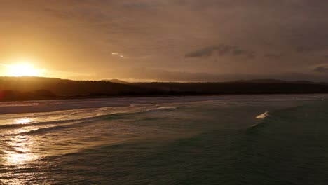 Aerial-establishing-shot-of-golden-sunset-over-Bay-of-Fires-in-Tasmania