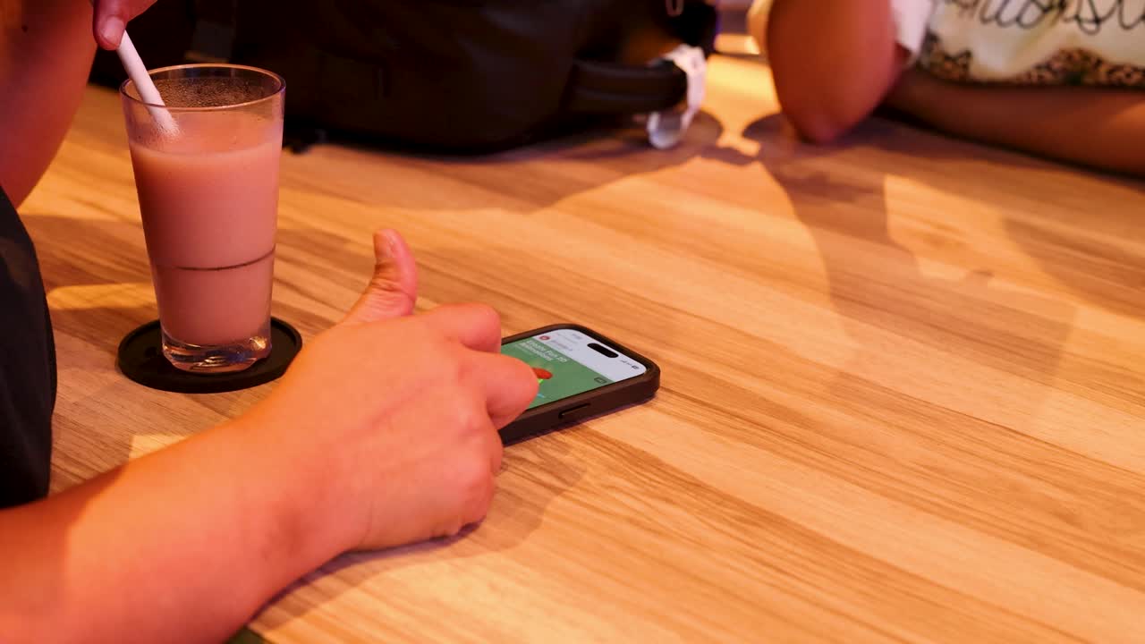 navegando por las redes sociales mientras disfruta de café helado