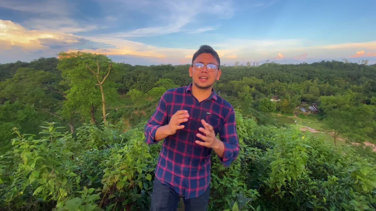 걷는 동안 내레이션을 하는 차 농장에 몰입한 진행자의 정적인 모습