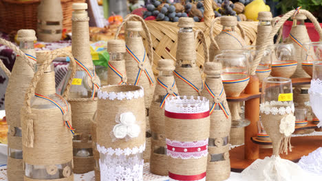 handmade traditional woven products on display at rustic market booth with jars of food and traditional crafts