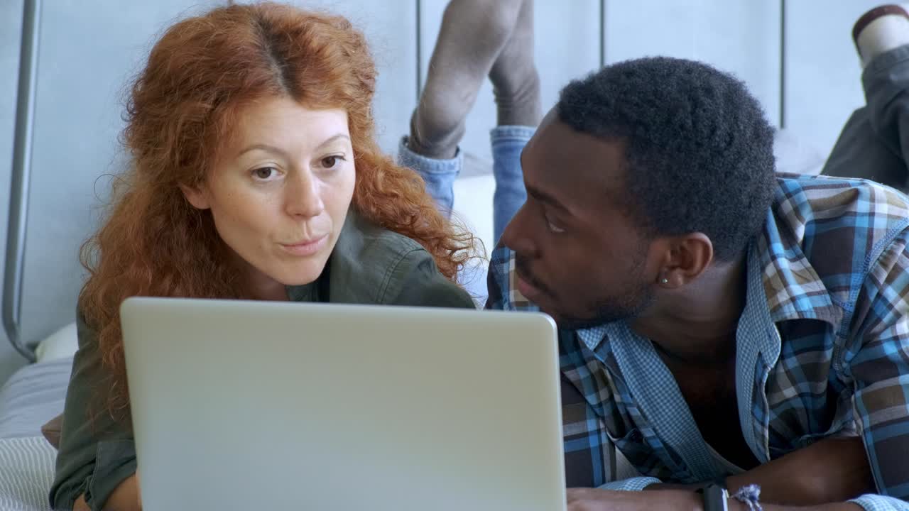 Couple Using Laptop in Bed