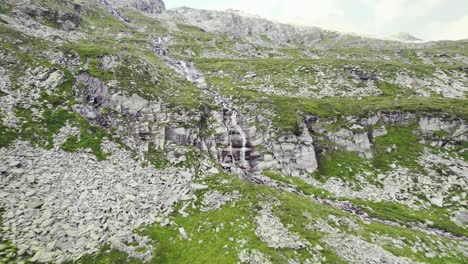 小瀑布在岩石和草地之間的山脈內