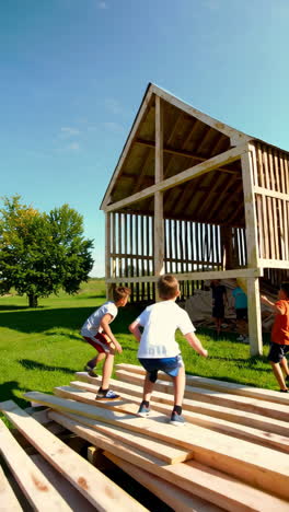 children playing and exploring a wooden structure under construction