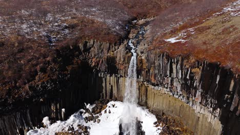 Establishing-aerial-shot-fly-natural-Svartifoss-waterfall-Icelandic-landscape