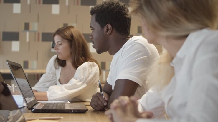 Équipe créative assise à une table avec des ordinateurs portables