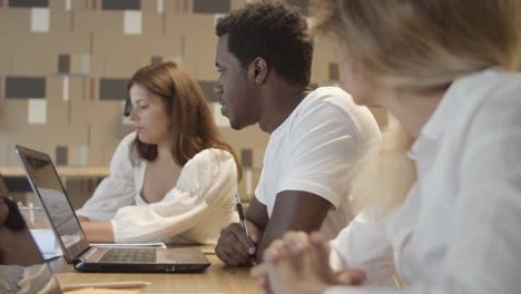 equipo creativo sentado a la mesa con portátiles
