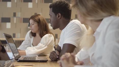 creative team sitting at table with laptops