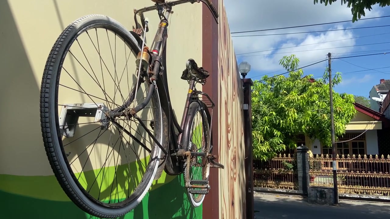 Bicicletta olandese vintage appesa a una parete in una zona residenziale