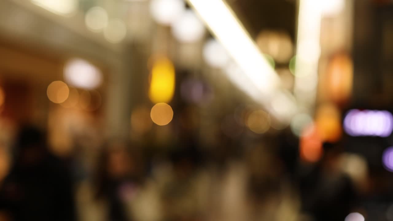 초점 밖의 사람들이 바쁜 실내 공간에서 움직입니다.