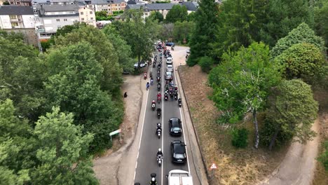 Biker-club-leaving-a-city,-aerial-drone-view