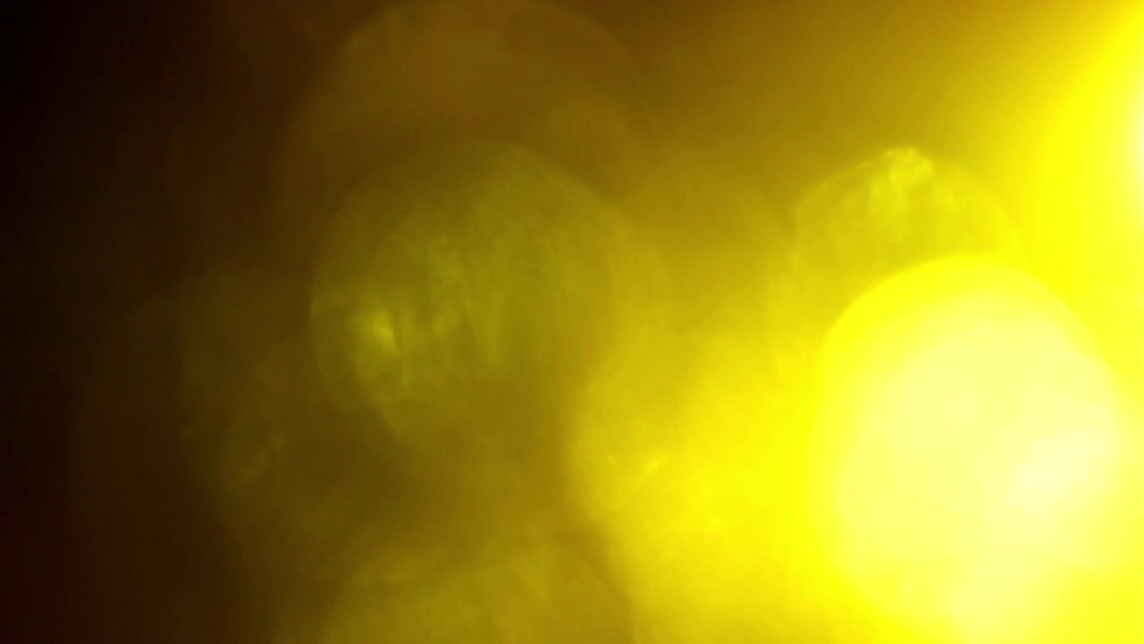 Fughe di luce bokeh calde e dorate che si muovono su sfondo nero