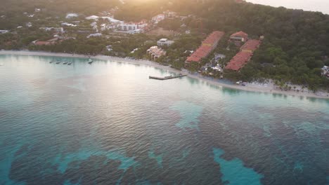 boats on the waves in azure seawater, palms and resorts on caribbean coast