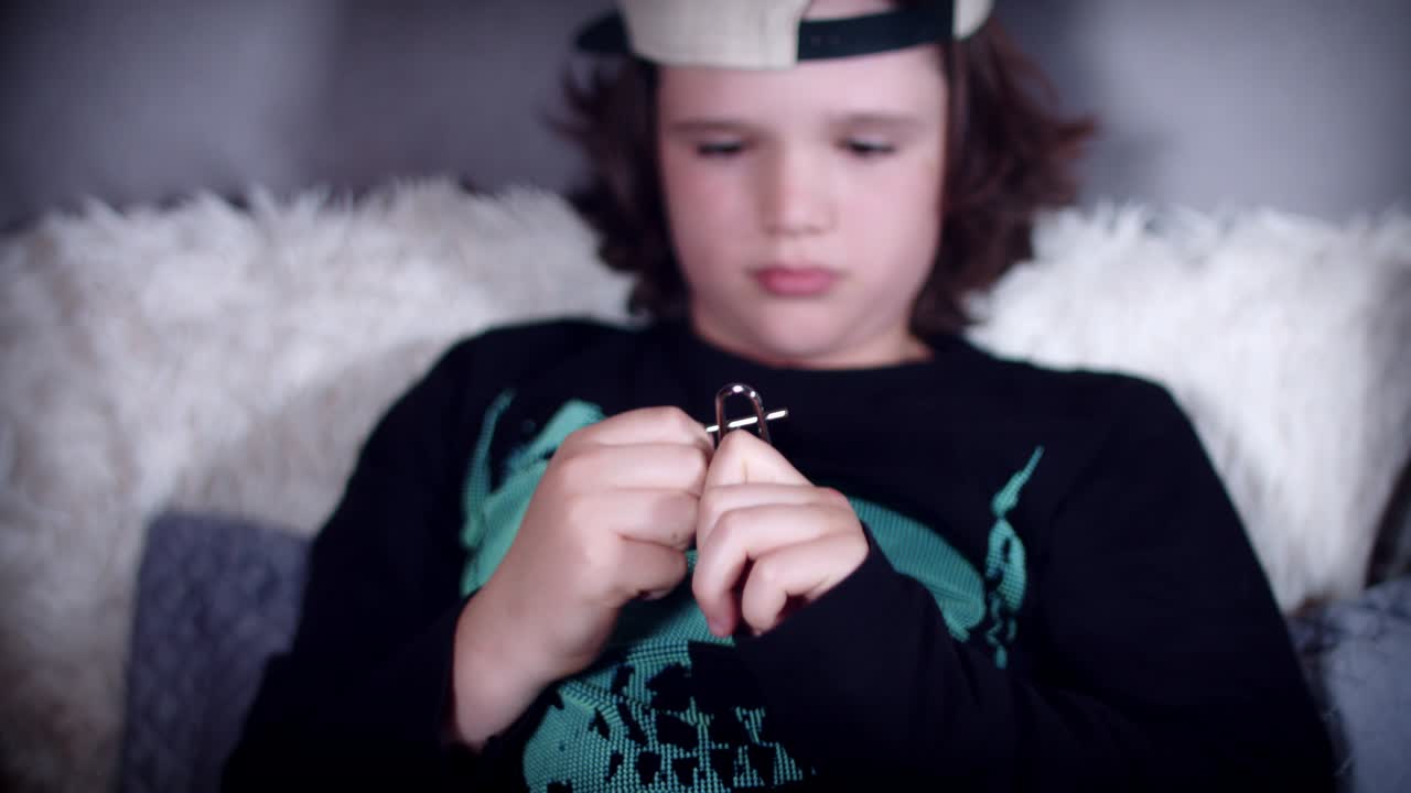 4k di mani di bambino che giocano con un rompicapo di metallo