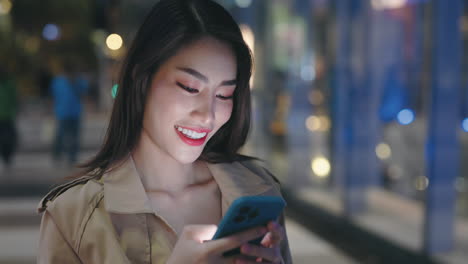 woman using phone at night in a city