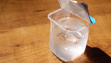 a clear plastic container filled with water on a wooden table