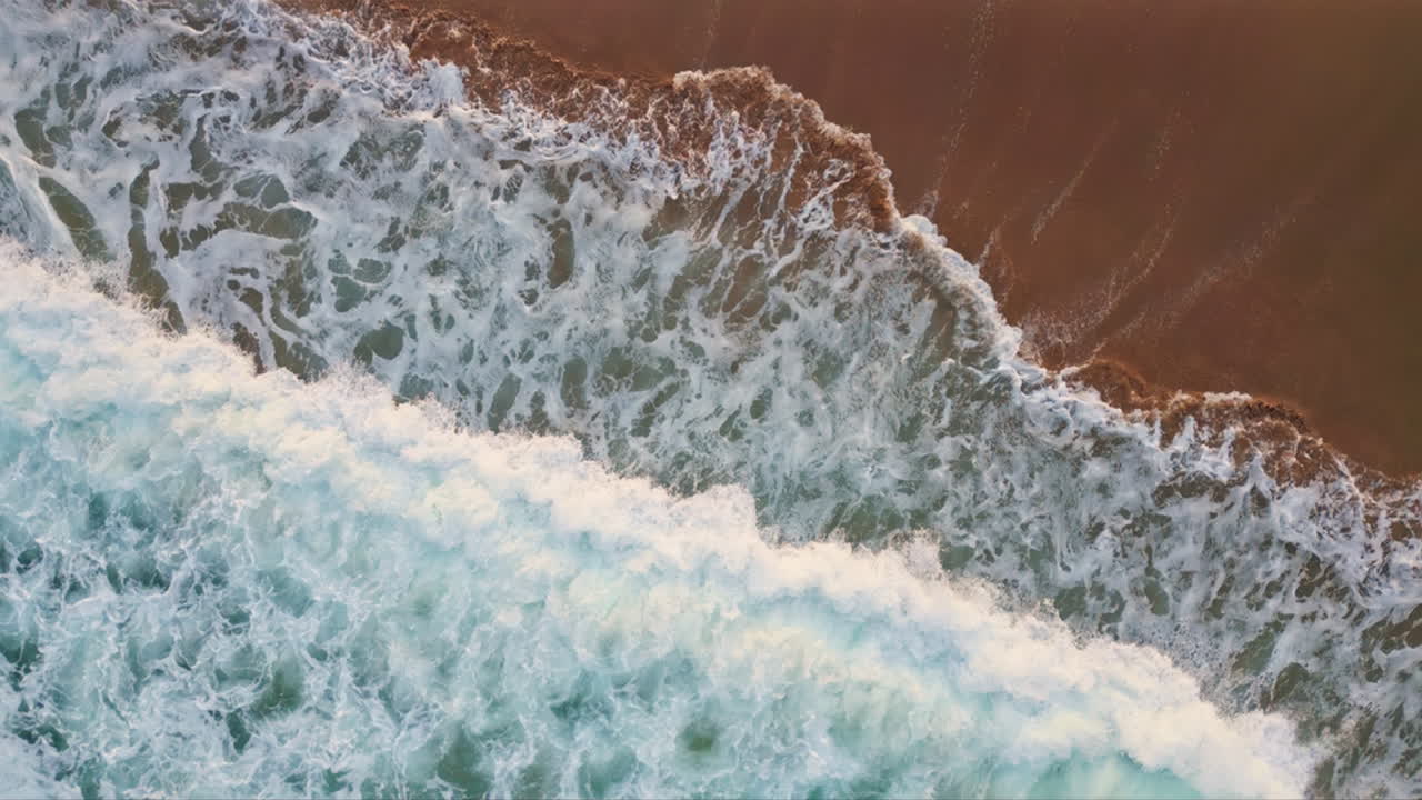 Foamy ocean washing sand vertically closeup. Turquoise water rolling seashore