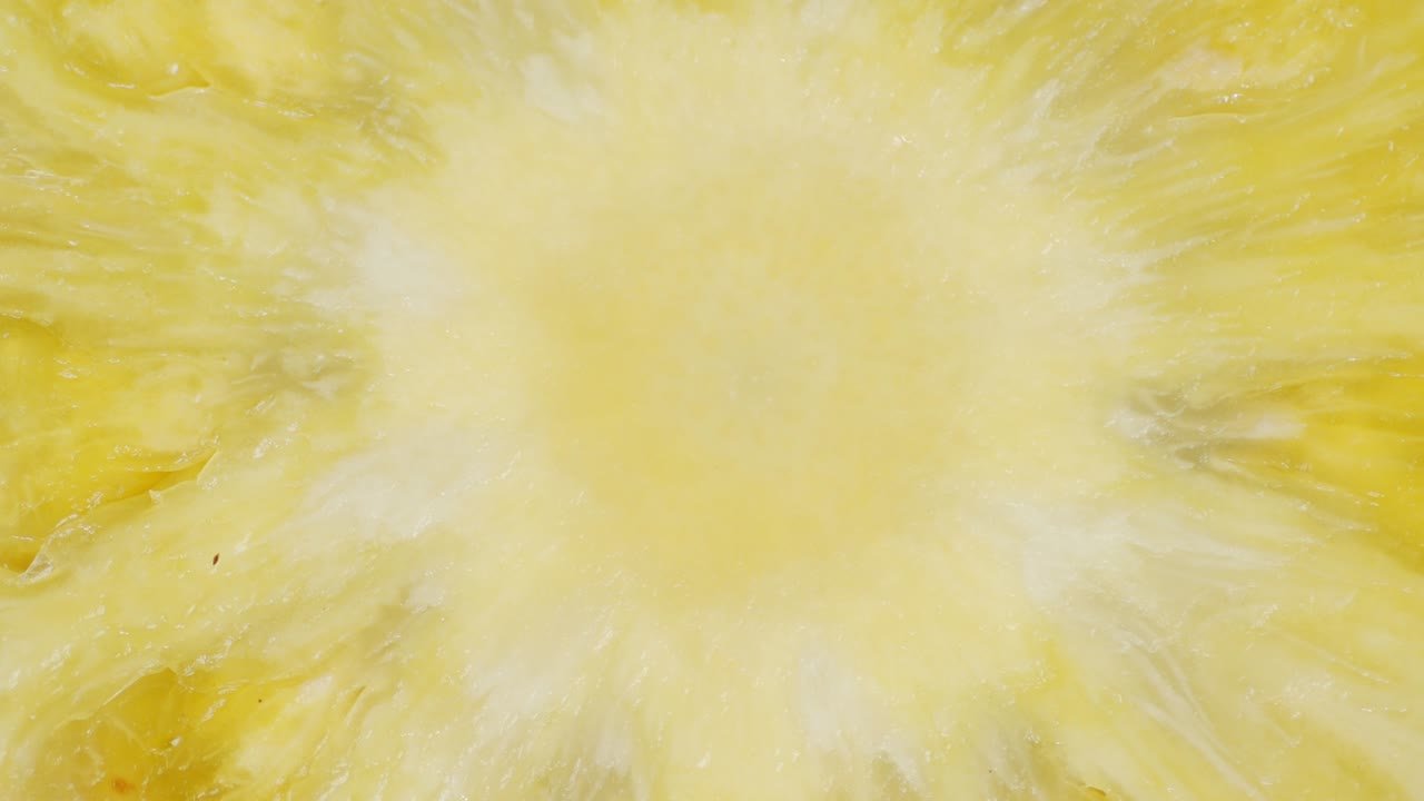 кусочек ананаса медленно вращается. макро фон.