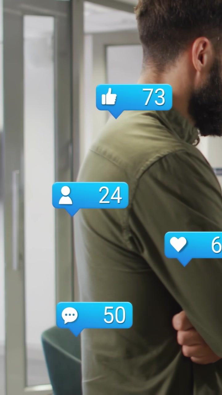 Vertical video: Standing man watching notifs rising for likes at work in olive shirt, copy space
