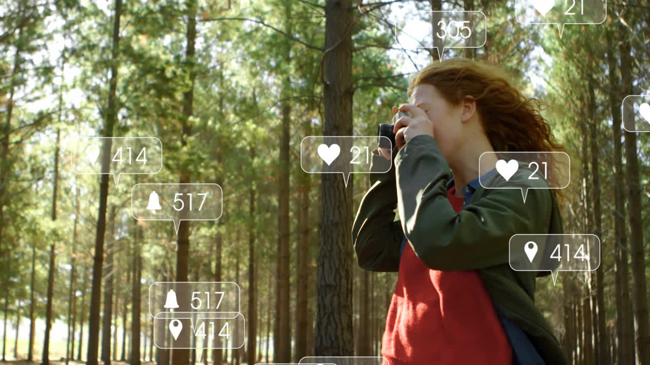 female photographer raising camera in pine forest, displaying floating social media marketing icons