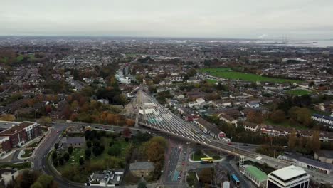 reverse aerial dolly view from drone, overlooking to dumdrum bridge luas station next to dumdrum shopping mall in south dublin, ireland