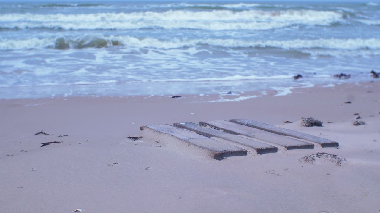 빈 발트해 백사장 해변, 환경 오염 문제, 흐린 날, 중간 샷에 모래, 쓰레기, 쓰레기로 덮인 오래된 나무 에팔 팔레트