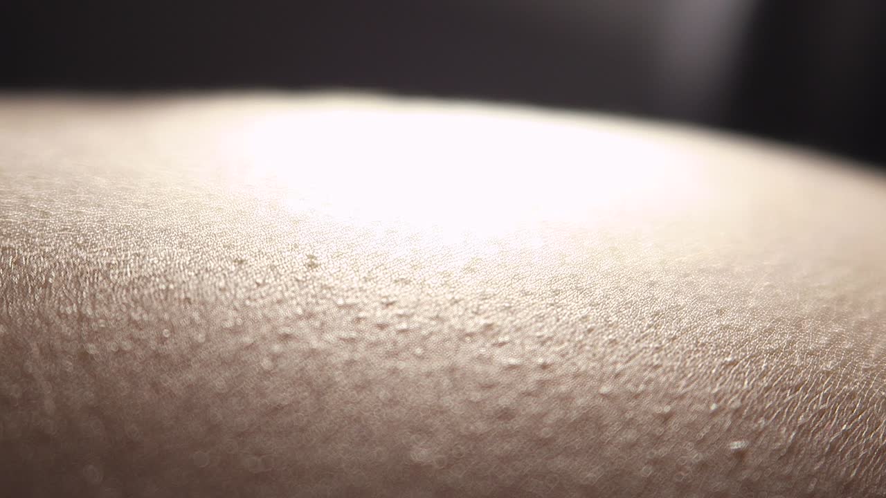 Intimate close-up of a hand stroking a woman's body.