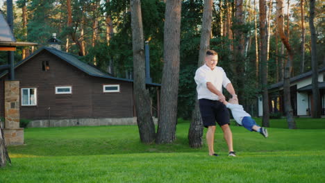 Ein-Gesunder-Vater-Spielt-Mit-Seinem-Kleinen-Sohn-Im-Hof-Seines-Hauses-Zeitlupenvideo