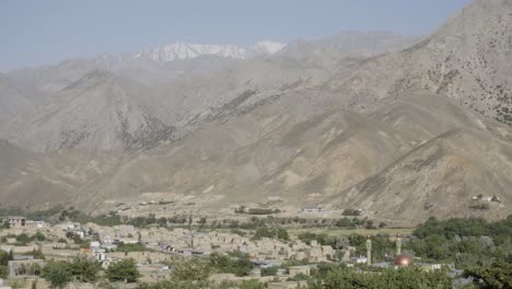 historical town near steep slopes and snowy peaks in panshir valley, static view