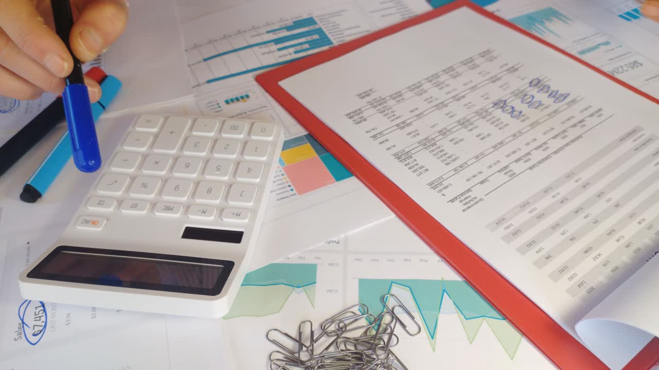 las manos de un contador trabajan en una calculadora y preparan un informe financiero