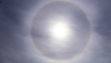 太陽の周りの円形のハロと 浮かぶ灰色の雲の美しい映像