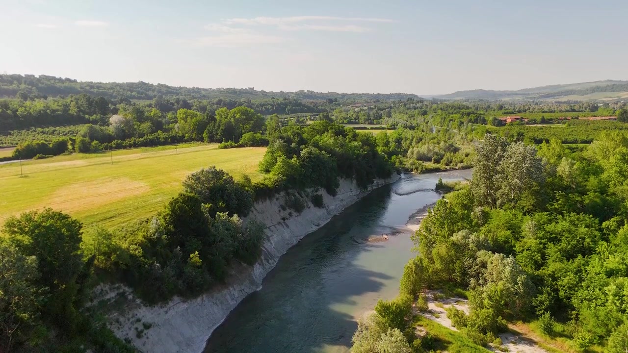 Ripresa aerea con drone di un fiume che serpeggia attraverso foreste verdi e ripide scogliere bianche.