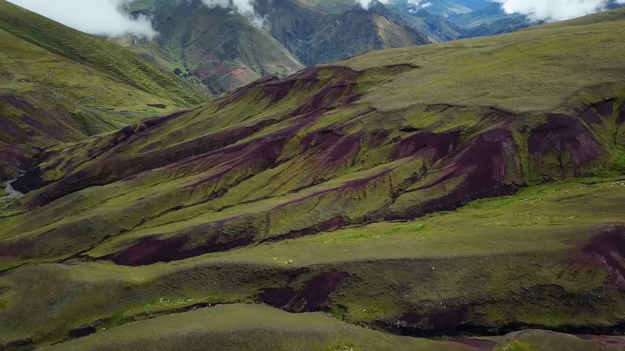Inquadratura aerea, panoramica, da drone, che domina ruscelli, formazioni naturali verdi e nebbia, sulle Ande, in una giornata nuvolosa, vicino a Cuzco, in Perù.