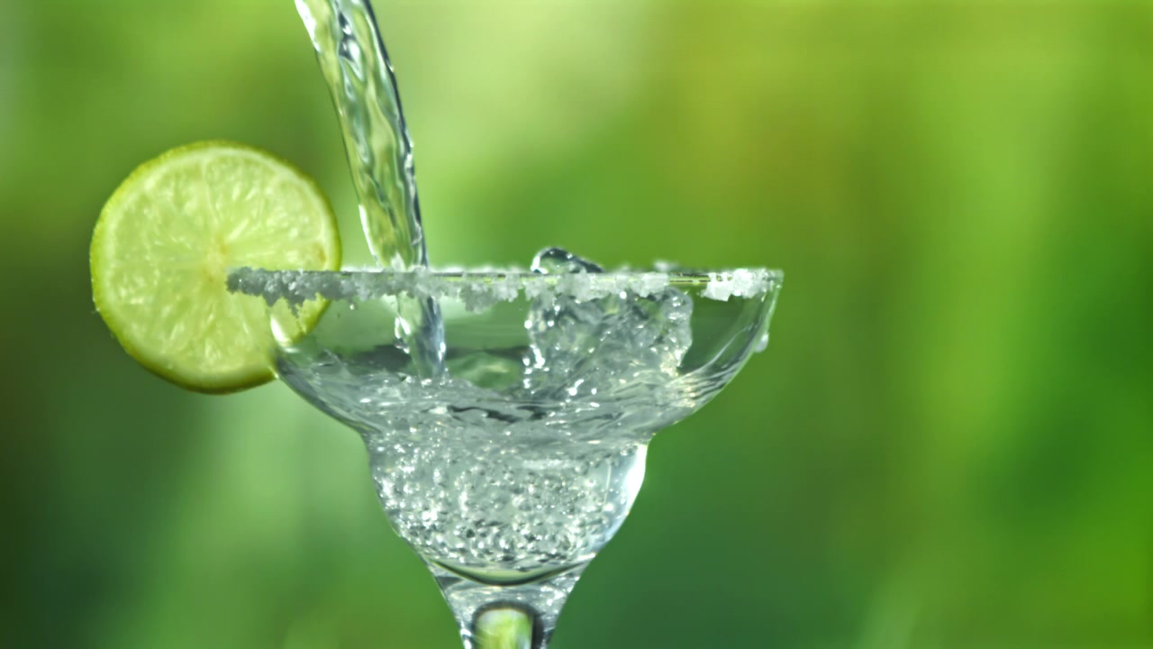 Cocktail Margarita rinfrescante versato in un bicchiere con bordo salato e lime