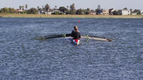 four senior caucasian men and women rowing boat on a river