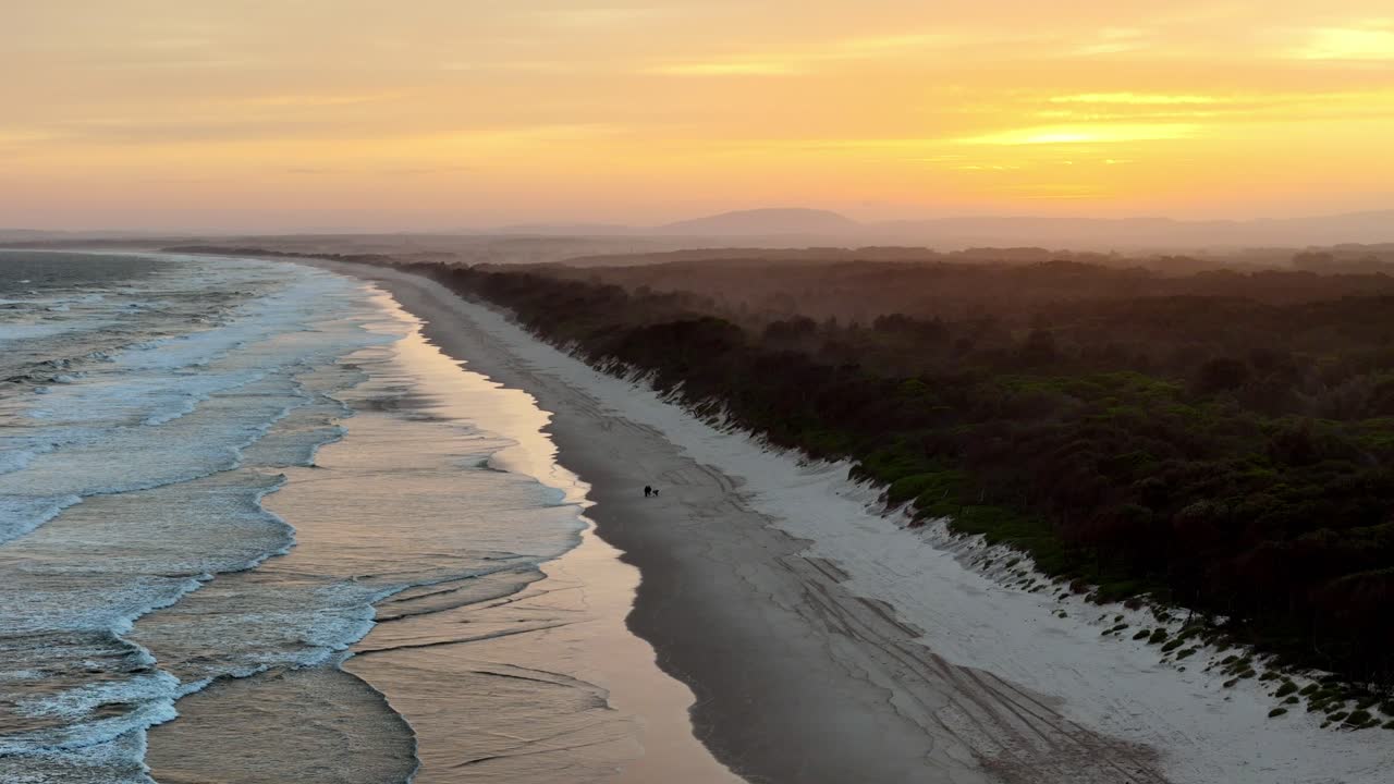 Sunset casting a warm glow over a deserted beach, The coastline adorned by the day&rsquo;s last light