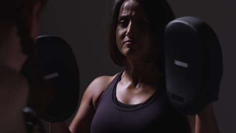 Nahaufnahme-Einer-Studioaufnahme-Von-Zwei-Reifen-Frauen-In-Fitnesskleidung,-Die-Gemeinsam-Boxen-Und-Sparring-Trainieren-2