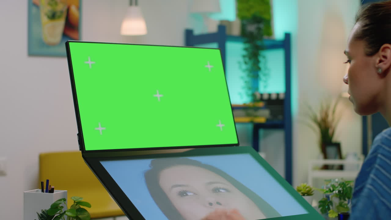 Photographer with horizontal green screen on computer