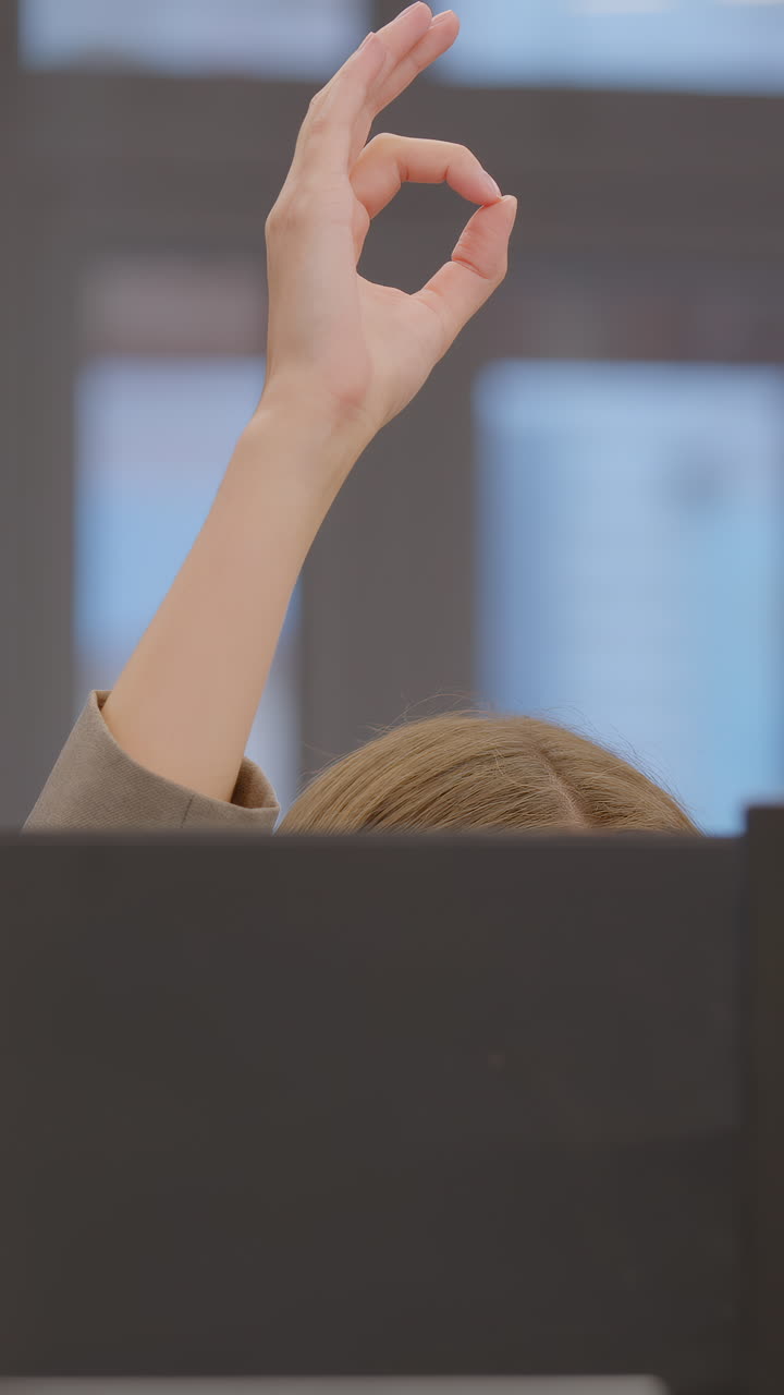 Woman in office, ok gesture